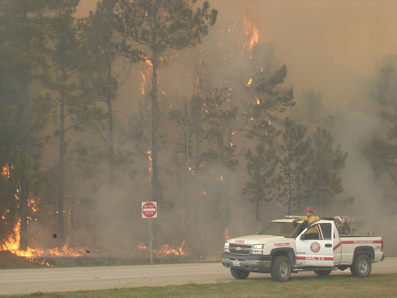 A fire management truck parked along the road next to a wildfire at Camp Lejeune in 2011