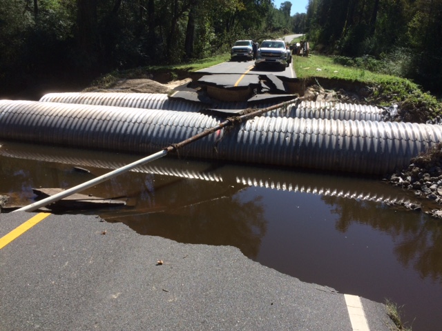 A photo of a damaged road with drainage pipes exposed