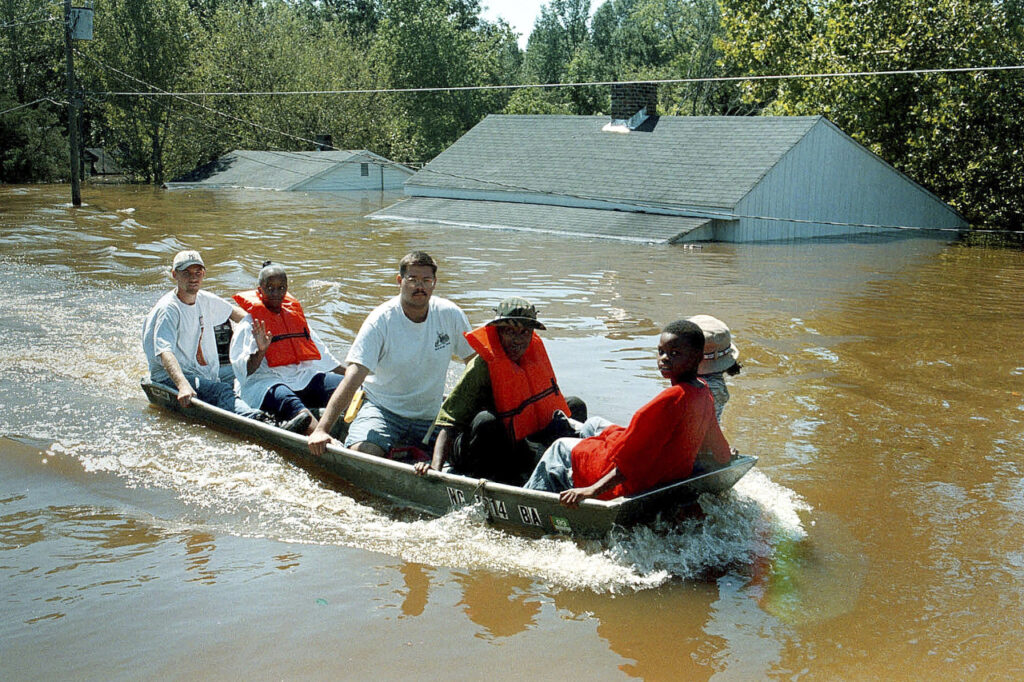 A photo of Princeville residents riding in a boat through the town after Hurricane Floyd in 1999