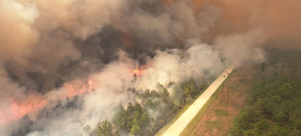 An aerial view of the Great Lakes Fire burning along a roadway
