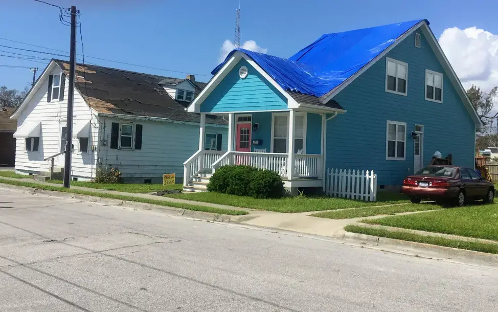A photo of a house in Beaufort with a blue tarp covering its roof