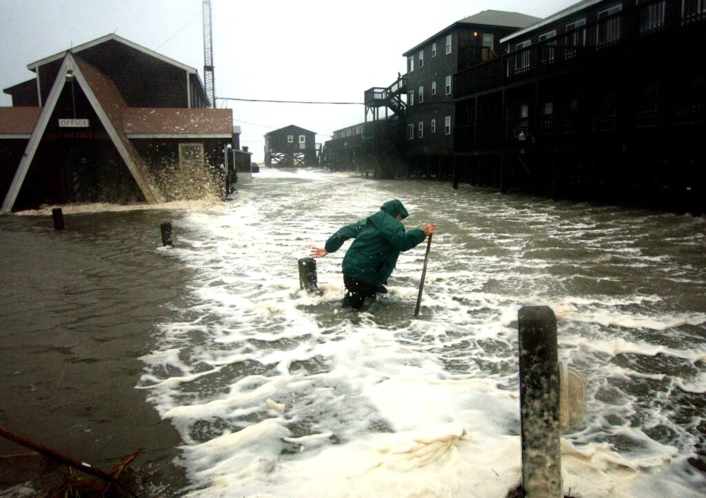 A photo of a man walking through a flooded motel parking lot during Isabel