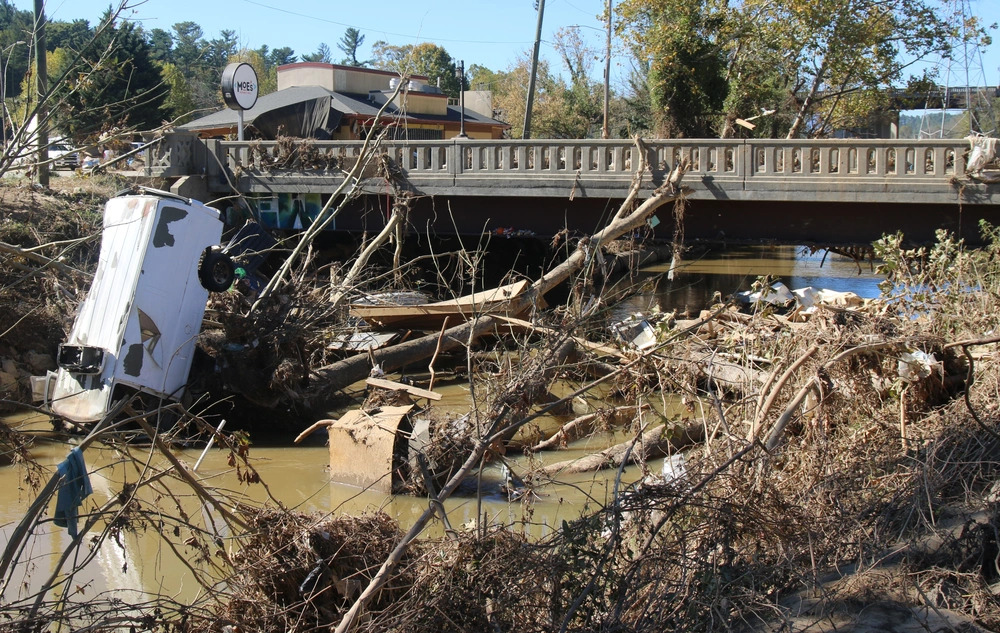 A photo of debris along the Swannanoa River in Biltmore Village following Hurricane Helene