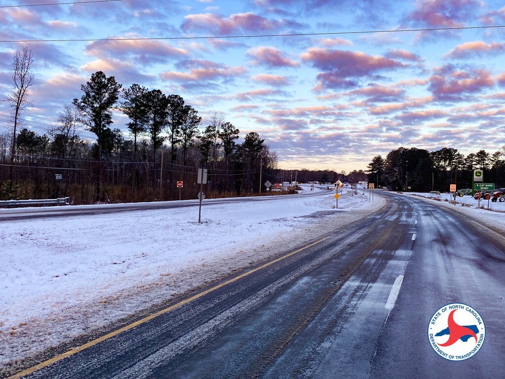 A photo of snow on the ground and slick spots on a road in Johnston County