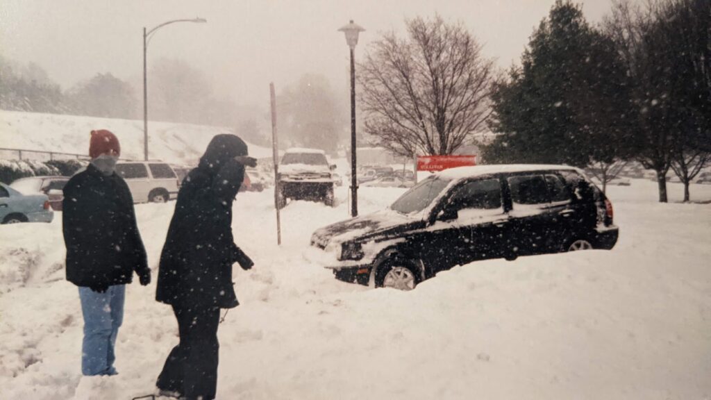 A photo of a car stuck in the snow in a parking lot at NC State