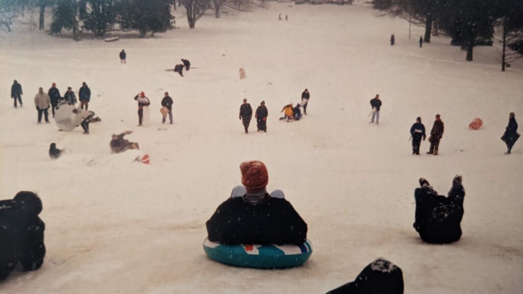 A photo of sledders sliding down a hill at NC State University