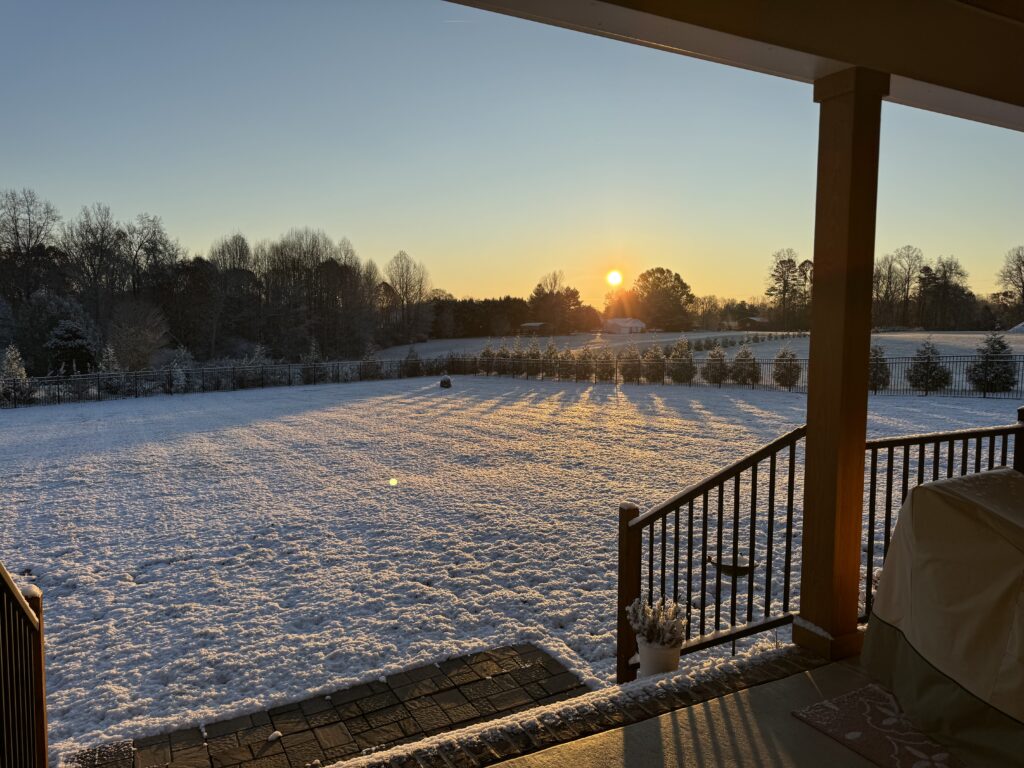 A photo of snow covering the ground with the sun rising in the skies on December 3, 2024