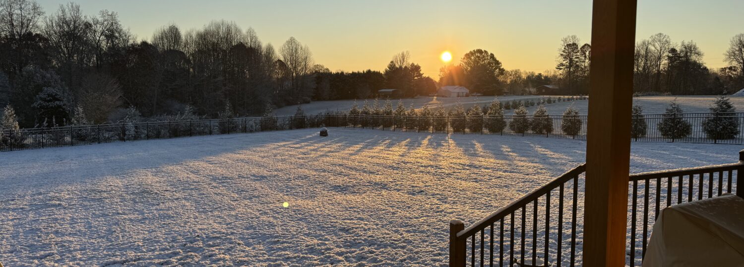 A photo of snow covering the ground with the sun rising in the skies on December 3, 2024