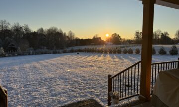 A photo of snow covering the ground with the sun rising in the skies on December 3, 2024