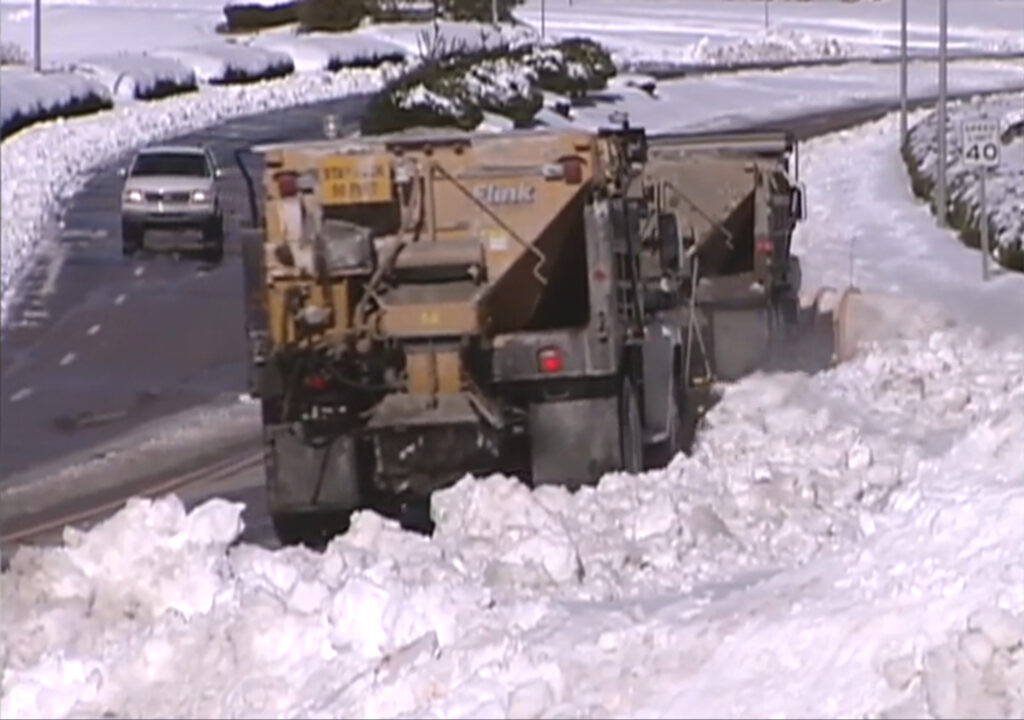 An image of plows scraping snow off the roads in the Triangle after the January 2000 storm