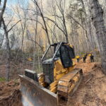 A photo of a dozer working on a containment line at the Deep Woods fire in March