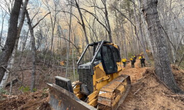 A photo of a dozer working on a containment line at the Deep Woods fire in March