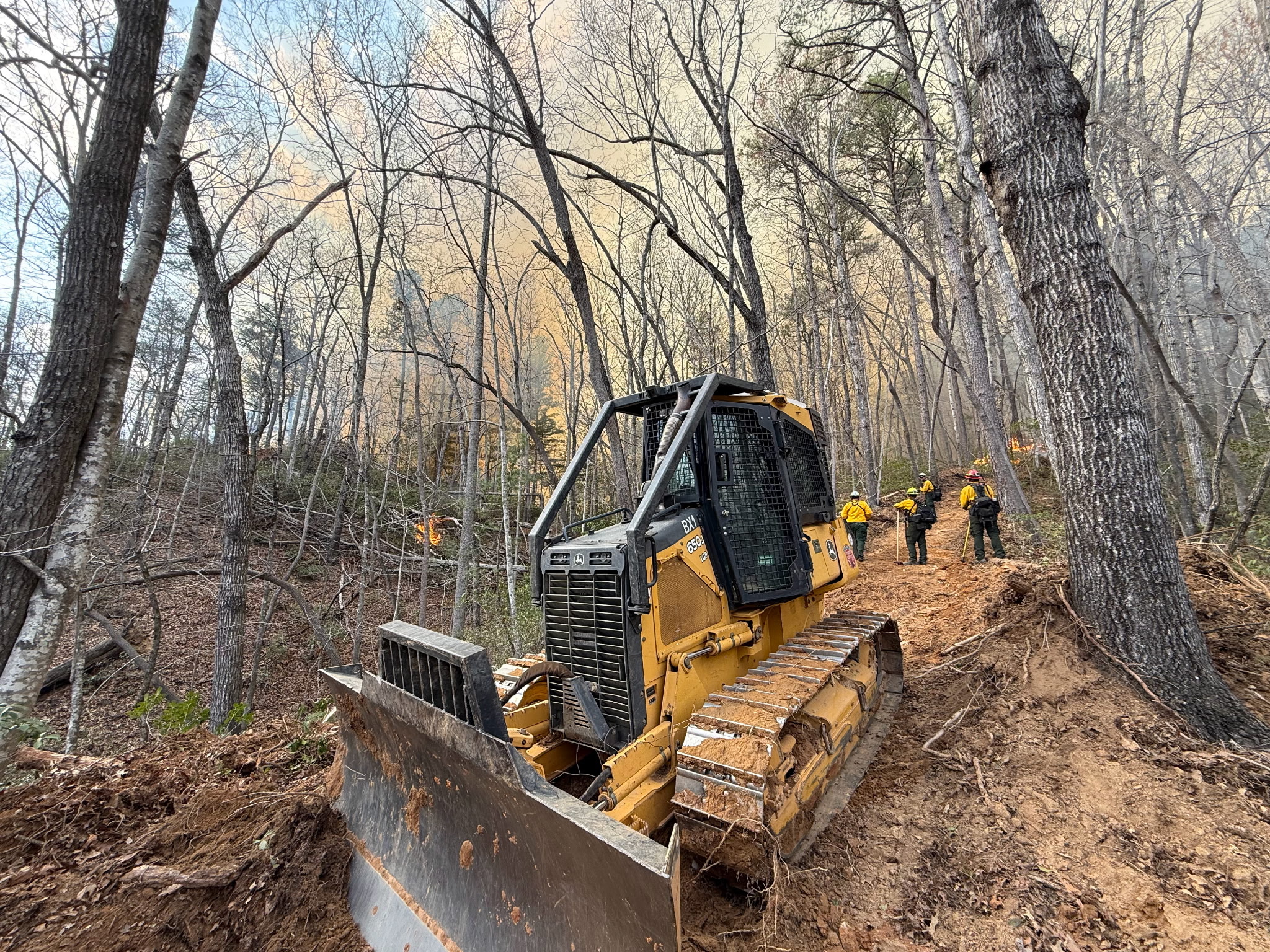 A photo of a dozer working on a containment line at the Deep Woods fire in March
