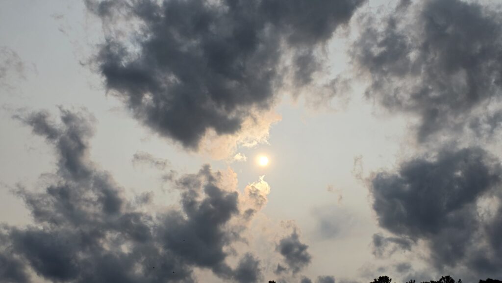 A photo of the sun in a hazy, cloudy sky over the Outer Banks on June 1