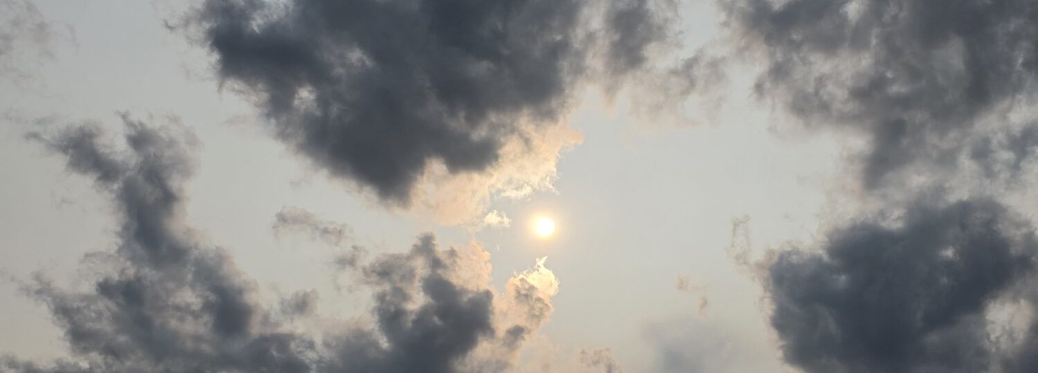 A photo of the sun in a hazy, cloudy sky over the Outer Banks on June 1