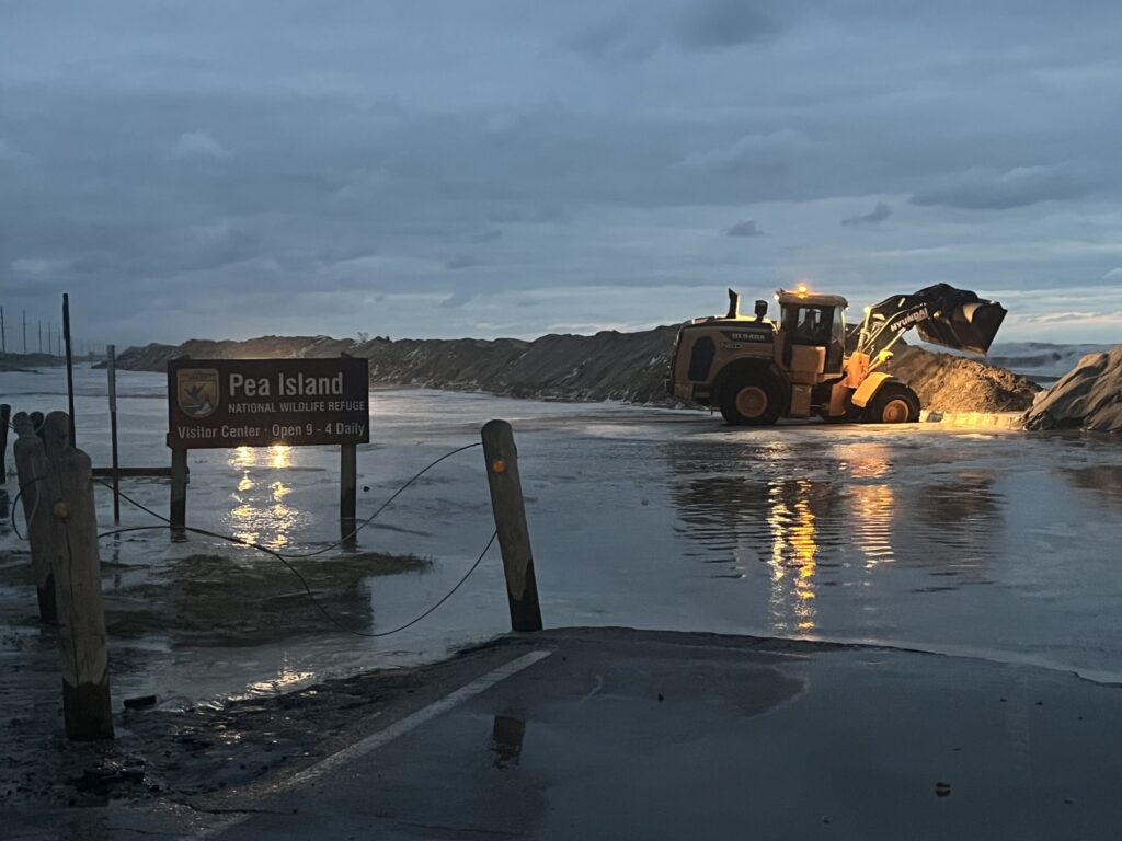A photo of a DOT crew repairing a breached dune along Highway 12 on Pea Island