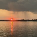 A photo of the sunset at Topsail Island with a rain shower visible in the distance