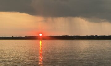 A photo of the sunset at Topsail Island with a rain shower visible in the distance