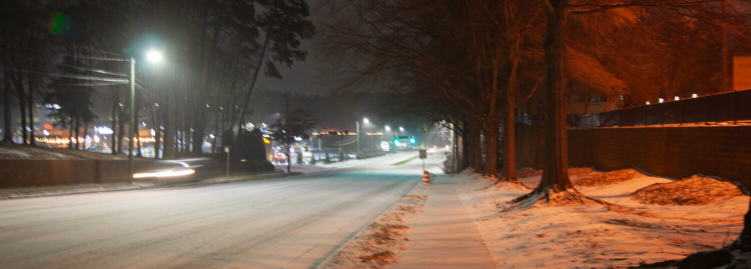 A photo of snow on a road and sidewalk in Raleigh, NC, on January 10, 2025