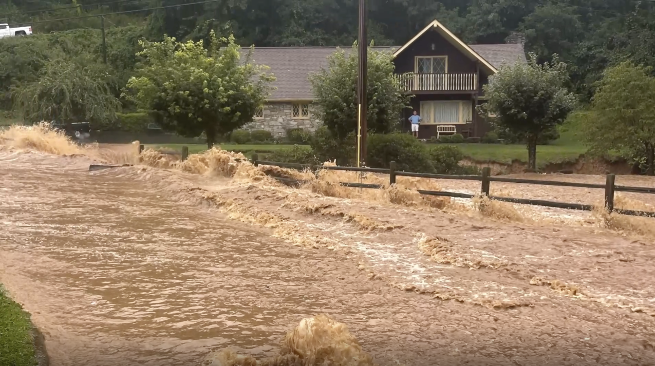 A photo of the Pigeon River rushing past a home during Tropical Storm Fred
