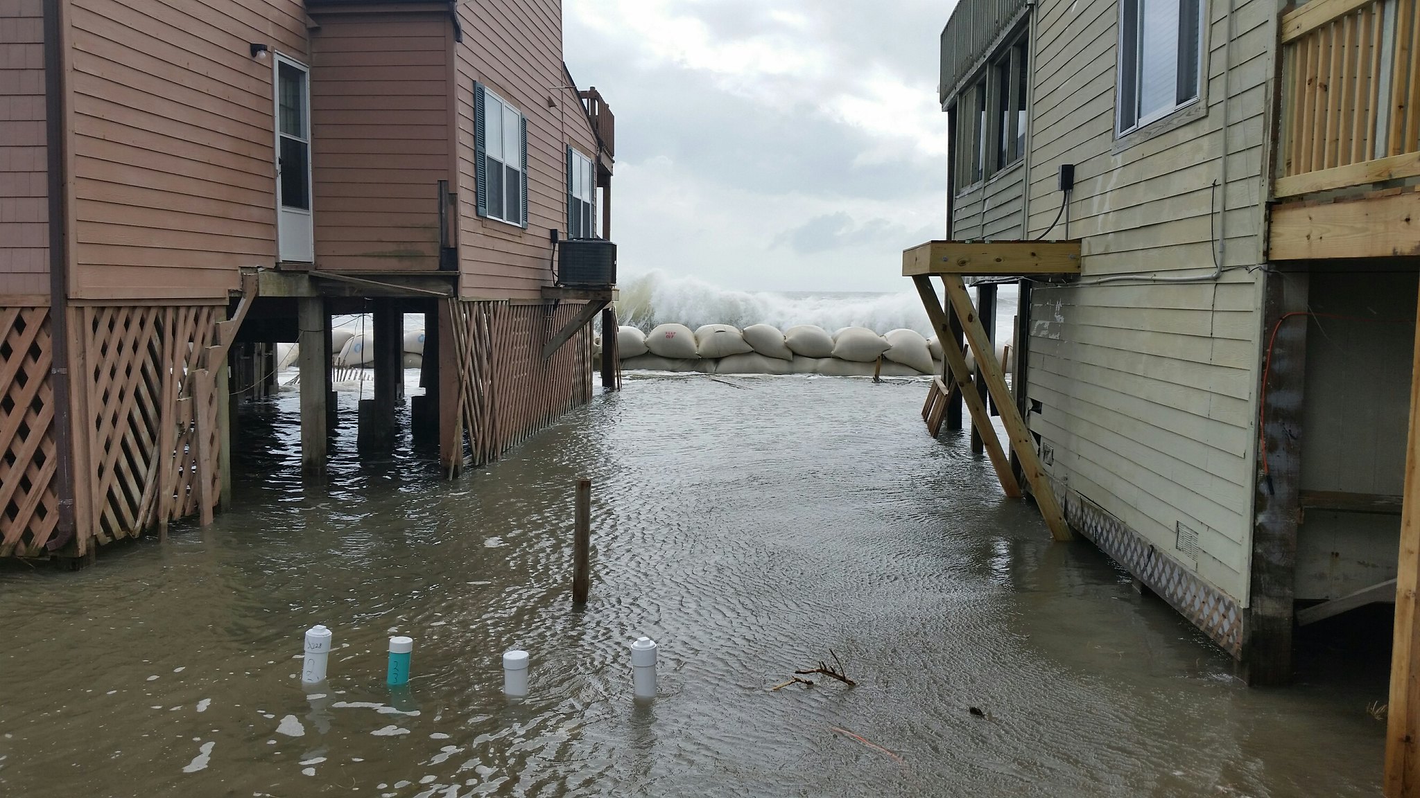 A photo of ocean waves crashing against sandbags in Onslow County in October 2015
